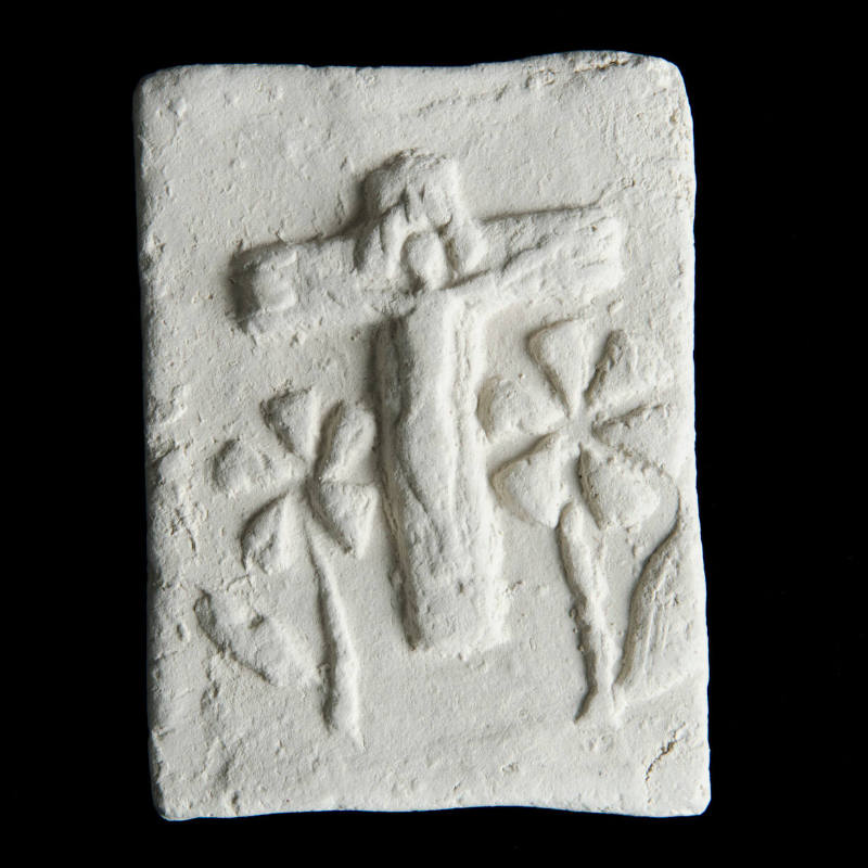 Sacred clay tablet with crucifix in center and large flowers below