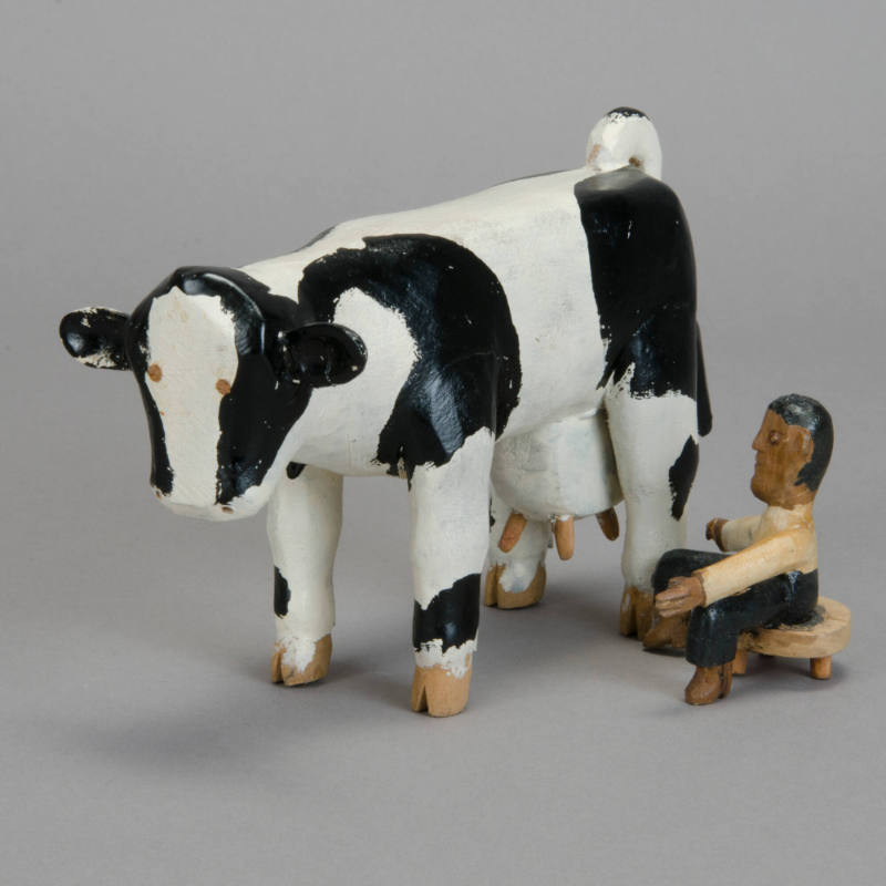 Man milking cow figurine