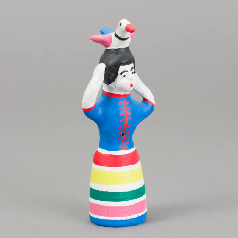 Figure, woman with bird on head and hands raised to head