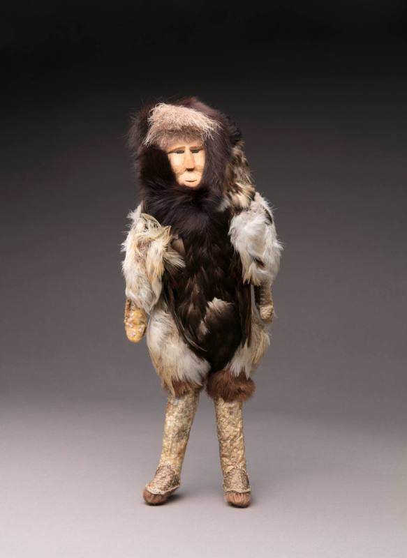 Male aaqucunguaq (doll) in bird feather parka and fish skin boots