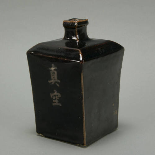 Black square vase with letters.
